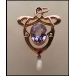 A stamped 9ct early 20th Century Art Nouveau pendant set with a large oval cut amethyst flanked by