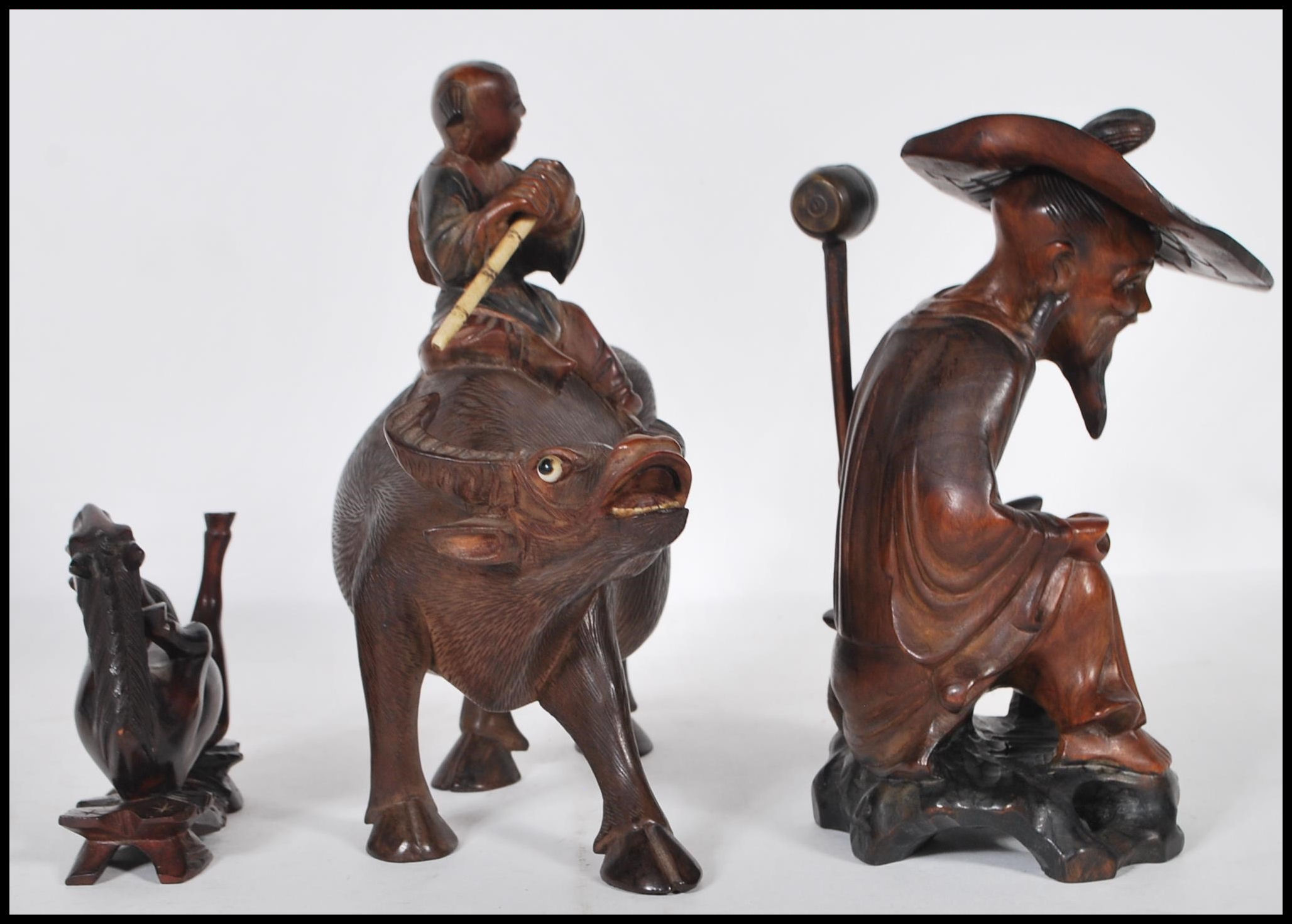 A group of 20th Century Chinese carved hardwood figurines to include a flute player riding on a - Image 5 of 5