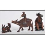 A group of 20th Century Chinese carved hardwood figurines to include a flute player riding on a