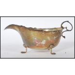 A silver hallmarked gravy boat by George Nathan & Ridley Hayes having a shaped rim and handle raised