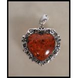 A decorative stamped 925 silver necklace pendant of heart shape with a large amber style center with