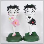 Two 20th century cast iron door stops modelled as Betty Boop. Each hand painted one in a pink