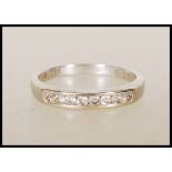 An 18ct English hallmarked white gold ring channel set with eight round cut diamonds. Hallmarked