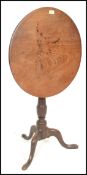 A 19th Century oak tilt top wine table / occasional tripod table, raised on a turned pedestal