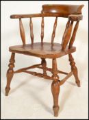 A 19th Century Victorian beech and elm smokers bow captains armchair being raised on double 'H'