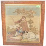 A 19th Century needlepoint tapestry framed picture depicting a shepherd boy with a dog seated