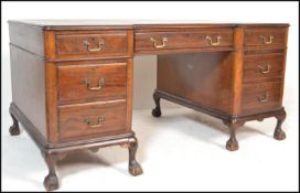 A mid 20th Century mahogany twin pedestal breakfront kneehole desk having leather insert top with