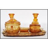 An early 20th Century Art Deco 1930's amber glass dressing table vanity set consisting of