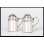 A pair of stamped 925 silver miniature salt and pepper condiments in the form of handled castores