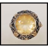 A vintage 18ct yellow gold ring having a central faceted cut oval Citrine set to a decorative