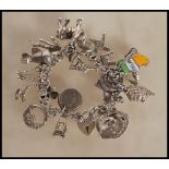 A silver heart lock charm bracelet having an assortment of charms to include hand, shire horse,