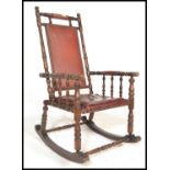 A Regency style rocking chair with open framework upholstered in a maroon coloured buttoned