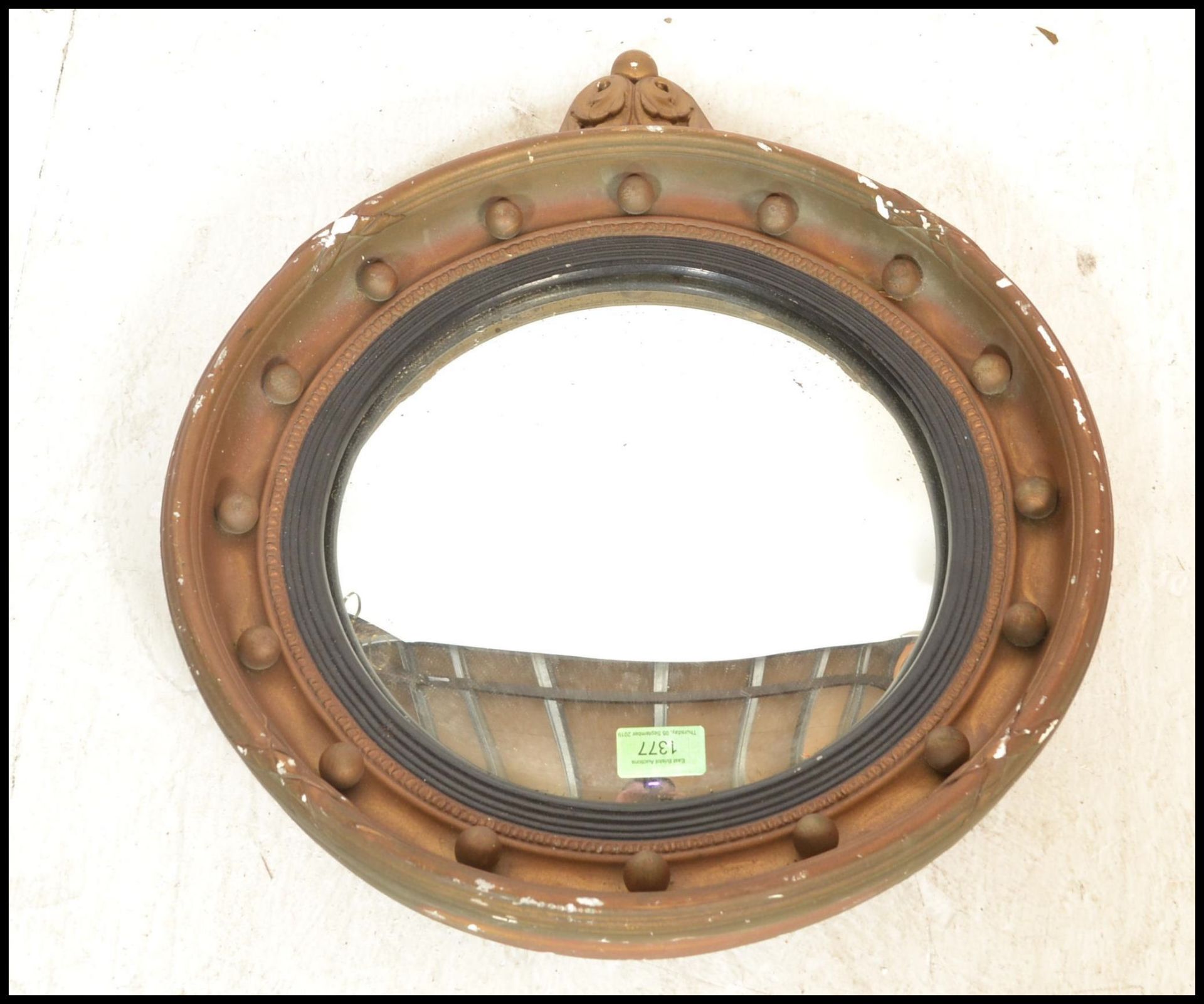 A early 20th Century gilt gesso convex porthole mirror with foliate finial. The circular frame