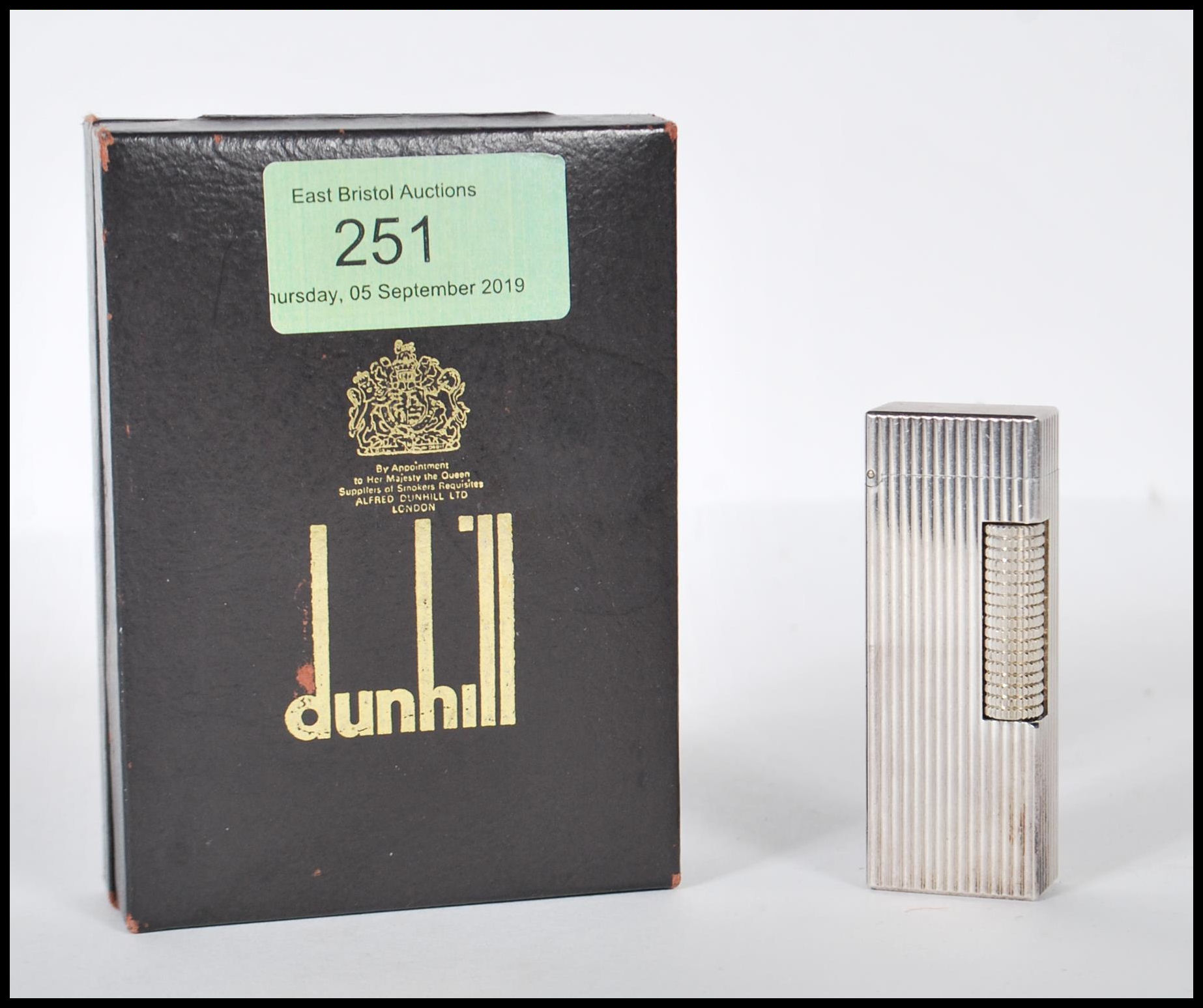 A vintage mid 20th Century Dunhill white metal rollagas lighter of reeded form, within original