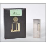 A vintage mid 20th Century Dunhill white metal rollagas lighter of reeded form, within original