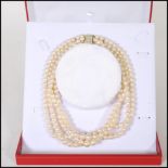 A 20th Century cultured pearl necklace having four strands of pearls united by a 9ct gold clasp