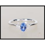 A stamped 18ct white gold ladies dress ring set with a central oval faceted cut sapphire stone