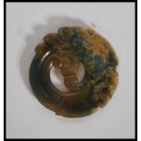 A 20th Century Chinese carved jade pendant medallion in the form of a dragon having carved scale and