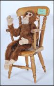 A vintage 1950's Merrythought made soft toy straw filled monkey with bead eyes and original label