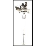A early 20th Century cast iron weather vane having scroll work to body with cockerel, moon and sun