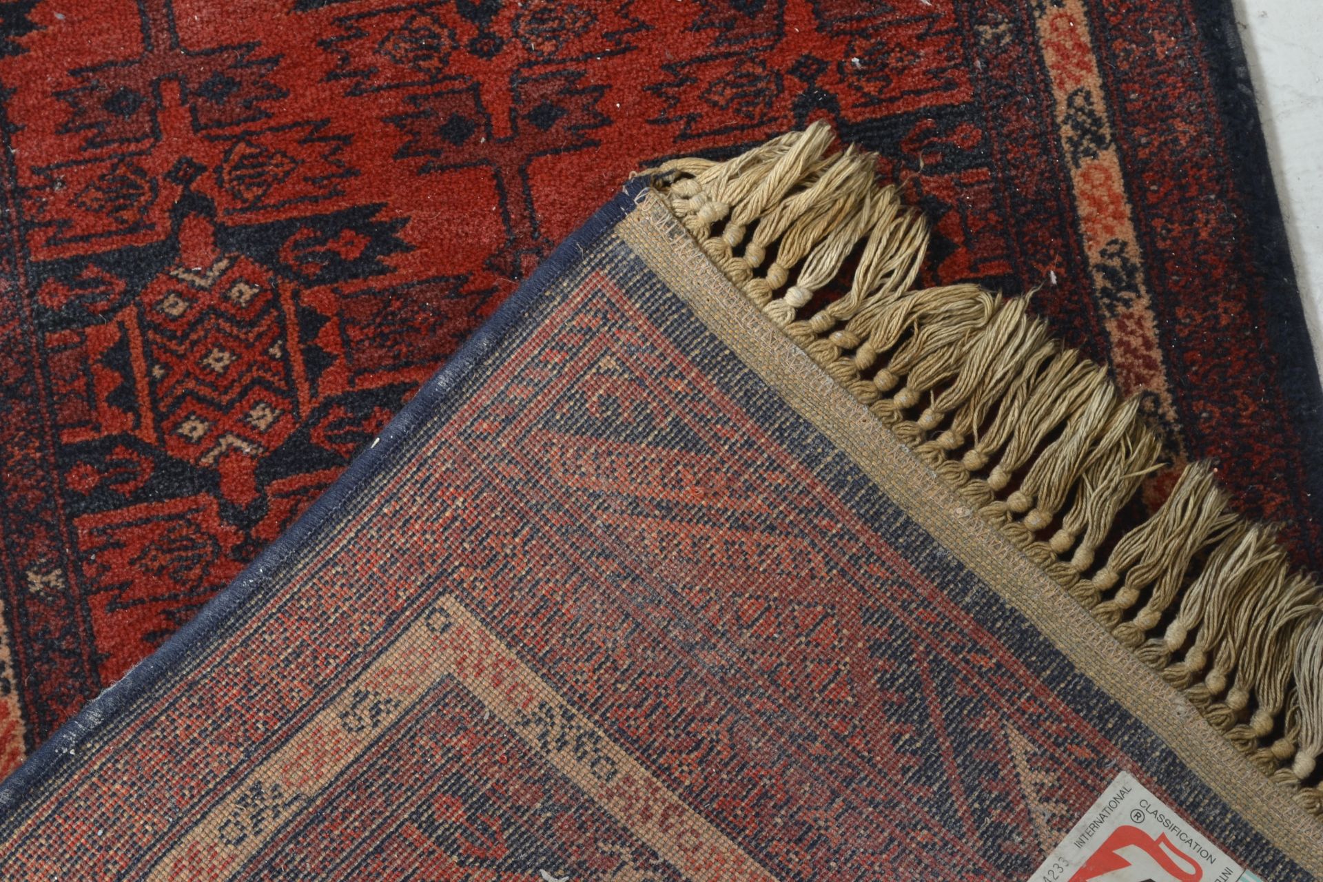 A Belgian Made ' Basra ' Tassled 'wool rug floor runner on red ground, central design of geometric - Bild 3 aus 4