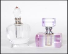 Two early 20th Century Art Deco faceted cut glass perfume bottles, one having a purple finish with