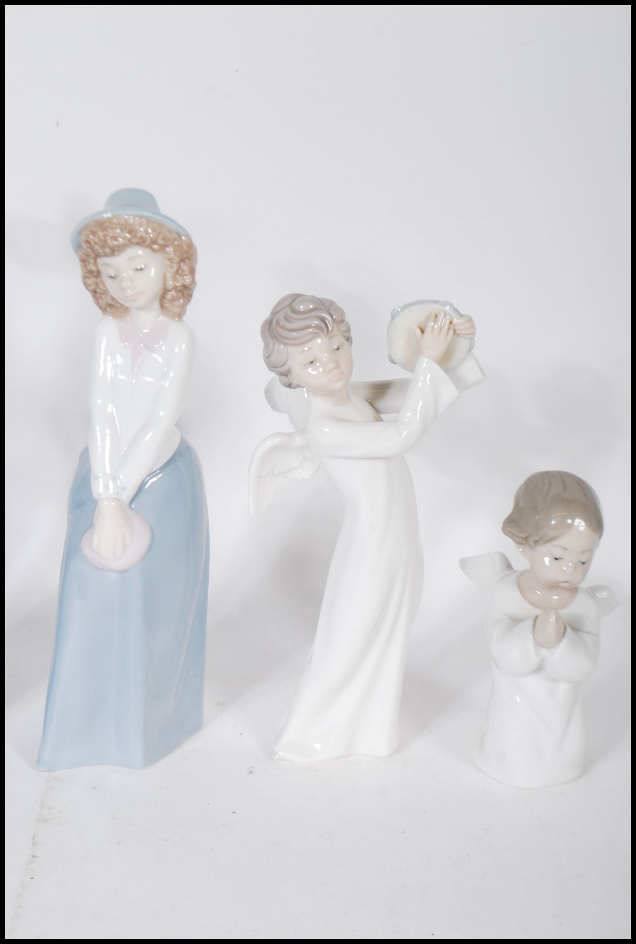 A collection of Nao and Lladro ceramic figurines to include a Lladro nun, a Lladro praying cherub, - Bild 4 aus 7