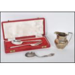 A collection of silver items to include a silver hallmarked fork and spoon set by Oliver & Bower