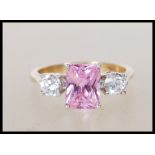 A hallmarked 9ct yellow gold ladies dress ring having central square cut pink stone flanked by two