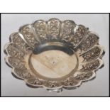 A stamped 800 silver dressing table trinket bowl having a scalloped rim with repousse floral