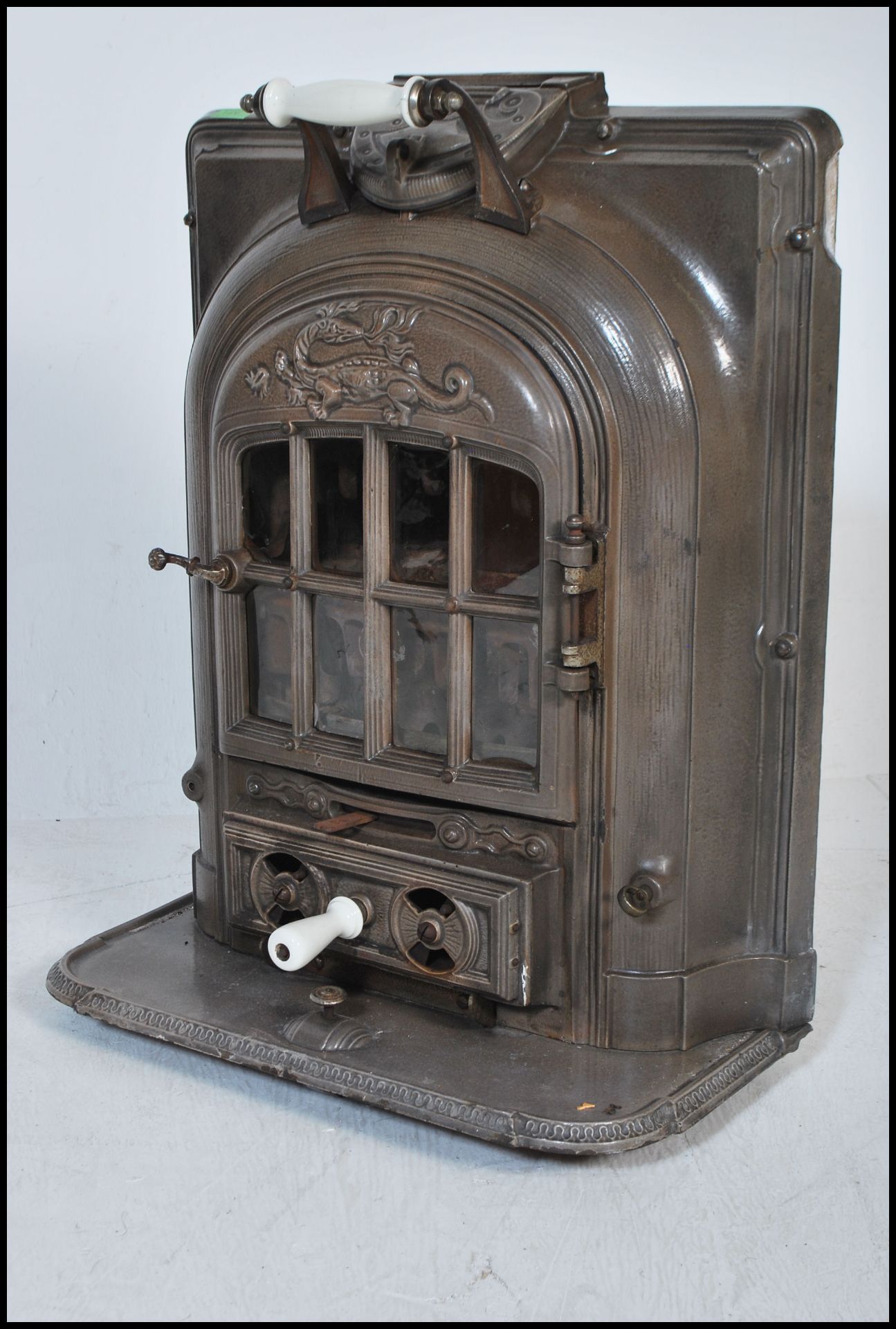 An early 20th Century La Salamandre antique wood burner gas stove, mounted on wheels having raised