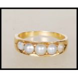A vintage 18ct yellow gold ring set with five graduating pearls. Unmarked but tests as 18ct with