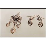 A 19th Century floral diamond and white metal pendant and earrings demi parure set, the pendant in