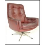A vintage retro 20th Century button back swivel armchair, upholstered in an oxblood leatherette