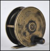 An early 20th Century Hardy Bros fly fishing reel having a brass foot with a single black handle.