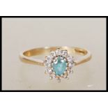 A 9ct gold English hallmarked ring set with a central blue oval cut stone having a halo of white