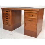 A mid 20th Century industrial Air Ministry teak wood twin pedestal desk, the right pedestal having