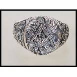 A stamped 925 silver gentlemans ring having the masonic symbol centre with floral and scroll