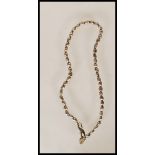 A silver hallmarked ladies necklace constructed from a string of silver beads with a heart shaped