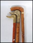 A group of three vintage 20th Century walking stick canes, two having brass duck head handles, the