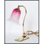 A vintage mid 20th Century brass adjustable swan neck desk lamp raised on a rectangular base with