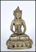 A 20th Century brass figure of a Indian deity seated crossed legged on lotus throne. The deity shown