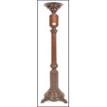 A 19th Century mahogany torchere plant stand having a turned knopped column raised of a round base