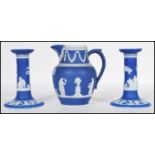 A pair of 19th Century Wedgwood jasperware blue candlesticks decorated with raised classical