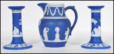 A pair of 19th Century Wedgwood jasperware blue candlesticks decorated with raised classical