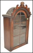 A 19th Century Dutch wall hanging cabinet having a glass paned door having a domed top with a