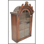 A 19th Century Dutch wall hanging cabinet having a glass paned door having a domed top with a