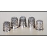 A group of five silver hallmarked thimbles dating from the 20th Century, each having engraved