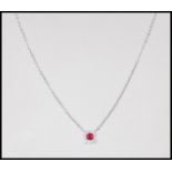 An 18ct white gold necklace pendant set with a a central ruby in a square halo set with diamond