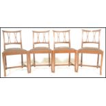 A set of four early 20th Century Arts and Crafts oak dining chairs retailed by Phillips of